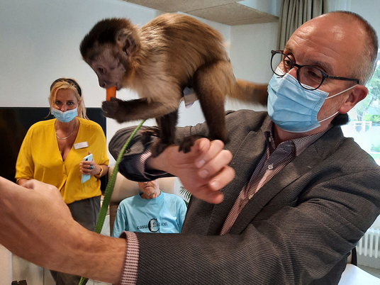 Geschäftsführer Walther Seiler spielt beim Besuch einer Filmtiertrainerin mit einem Affen.