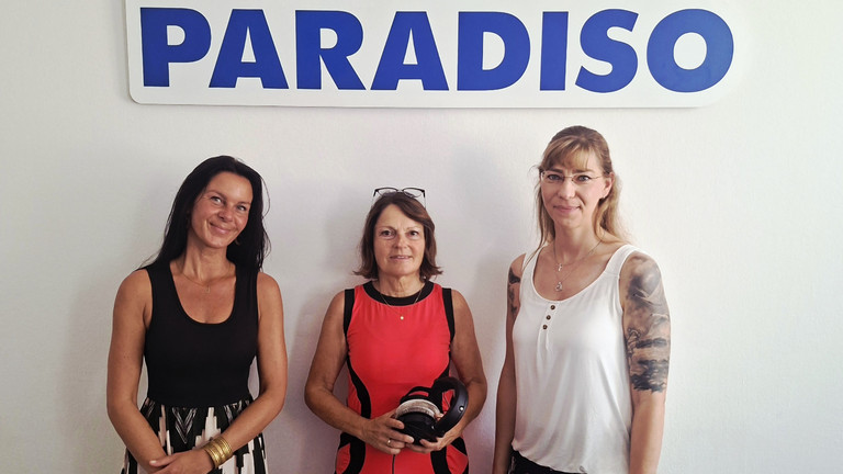 Kunsttherapeutin Sabrina Müller, Radiomoderatorin Julia Nogli und Pflegedienstleitung Stefanie Micklitza stehen unter dem Logo von Radio Paradiso bei der Sendung über die Ermöglichung wertvoller und erfüllter Momente am Lebensende im Diakonie Hospiz Woltersdorf. Kunsttherapeutin Sabrina Müller, Radiomoderatorin Julia Nogli und Pflegedienstleitung Stefanie Micklitza stehen unter dem Logo von Radio Paradiso bei der Sendung über die Ermöglichung wertvoller und erfüllter Momente am Lebensende im Diakonie Hospiz Woltersdorf.