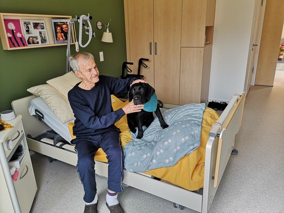 Hospizgast Norbert Schulz freut sich über den Besuch von Hund Balou.