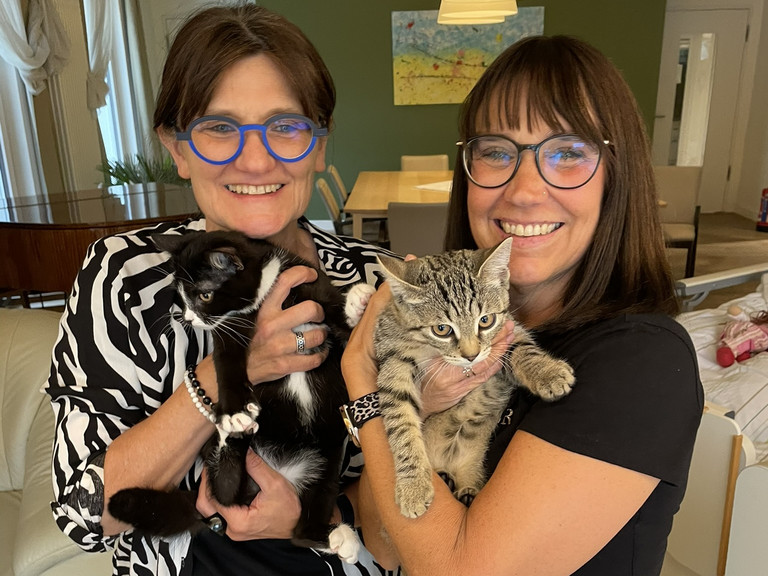 Zwei Frauen halten bei einem Tierbesuch im Diakonie Hospiz Woltersdorf zwei junge Katzen im Arm