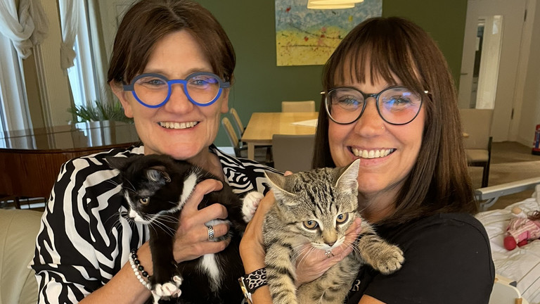 Zwei Frauen halten bei einem Tierbesuch im Diakonie Hospiz Woltersdorf zwei junge Katzen im Arm