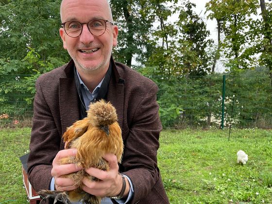 Geschäftsführer Walther Seiler mit einnem Huhn in der Hand, Nachrichten, Diakonie Hospiz Woltersdorf