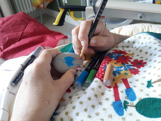 Gast bemalt Stein in Kunsttherapie - Diakonie Hospiz Woltersdorf